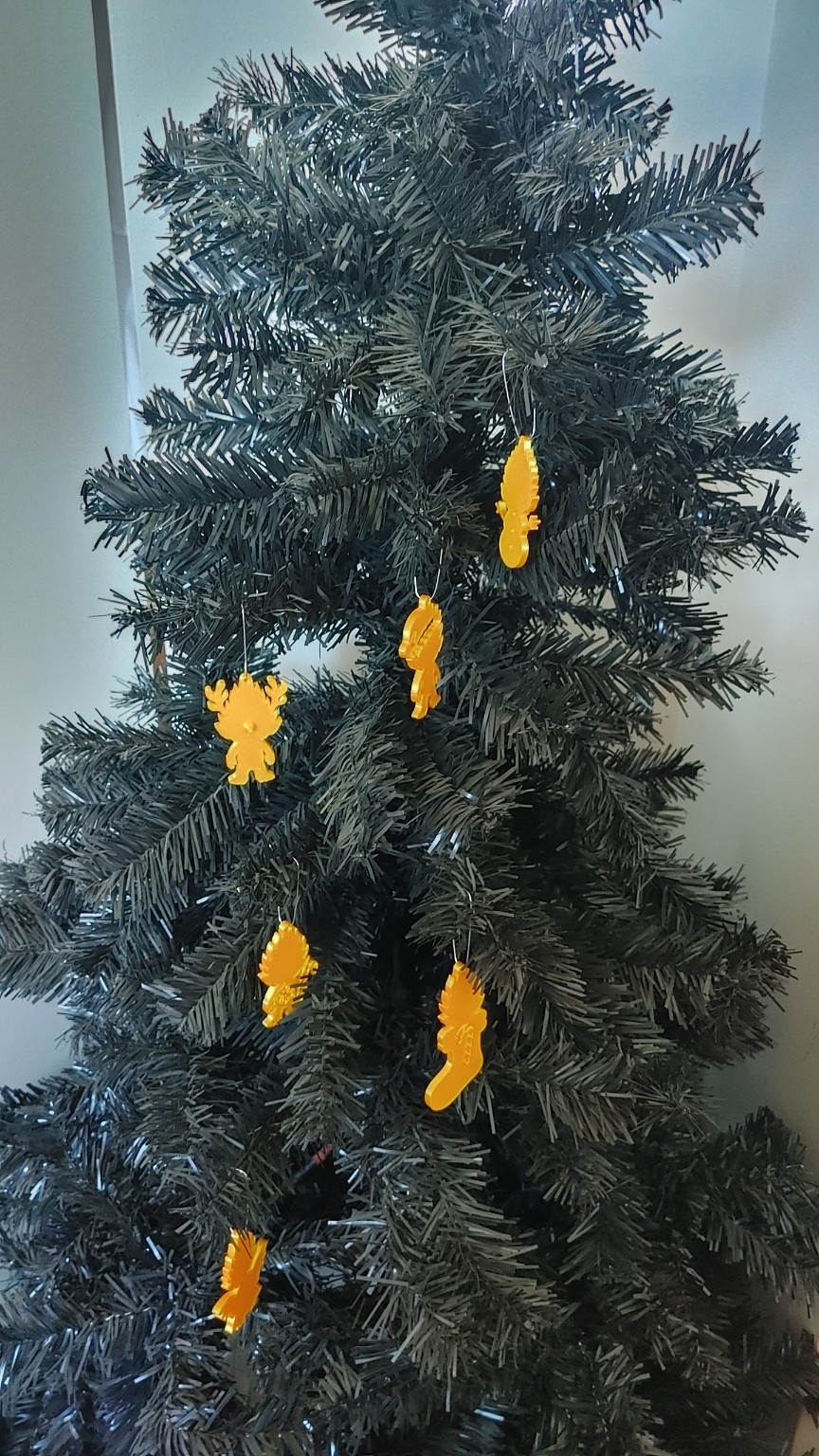 Six golden troll ornaments hanging on a Christmas tree